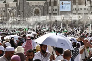 Muslim pilgrims walk along the Grand Mosque complex under water-mist fans installed in the Holy City of Mecca May 24, 2026, ahead of the annual Haj pilgrimage. — AFP pic