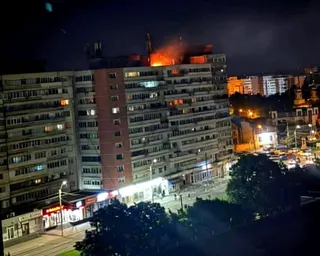 A fire burns on the roof of a 10-story block of flats after a drone crashed into the building in Galati, Romania.