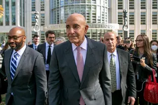 Tom Barrack, centre, with a group of other people leaving a building.