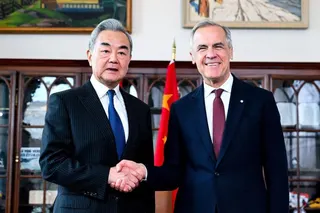 中国外交部长王毅（左）当地时间星期五（5月29日）在渥太华与加拿大总理卡尼会晤前握手致意。（彭博社）