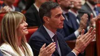 POOL/AFP via Getty Images Spain's Prime Minister Pedro Sanchez (R) and his wife Begona Gomez applaud as they listen to a speech during a visit to Tsinghua University in Beijing on April 13, 2026
