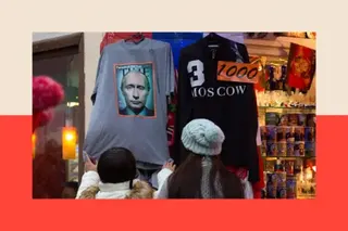 Bloomberg via Getty Images Two female shoppers wearing hats examine a grey t-shirt bearing the Time cover which is hanging outside a shop selling souvenirs