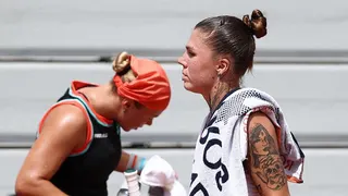 Diana Shnaider and Oleksandra Oliynykova at a change of ends during their 2026 French Open match