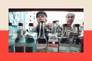 AFP via Getty Images A man and a woman look into a kiosk selling various brands of vodka in clear bottles.