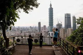 台湾官方上修今年经济成长率（GDP）逾9%，创16年新高。图为台北市民以台北101大楼为背景留影。 （路透社）