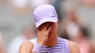 Iga Swiatek puts her hand to her face