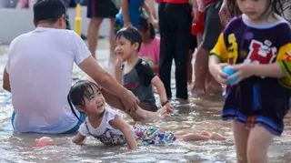 台灣家長陪同小孩在酷熱天氣中玩耍