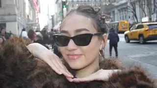 一名在紐約街頭穿著太陽眼鏡與毛絨上衣的紐約女服務生凱特・桑托斯