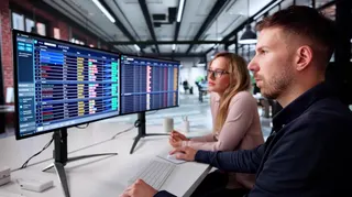 Man And Woman Study Spreadsheets On Computer
