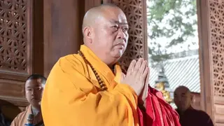 Shi Yongxin putting his palms together in a prayer position. He is wearing a yellow robe. File photo