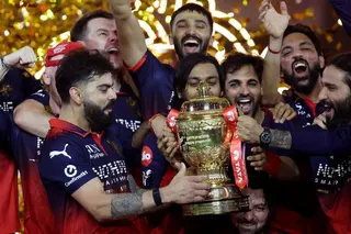 Royal Challengers Bengaluru's Virat Kohli lifts the trophy as he celebrates with teammates after winning the Indian Premier League