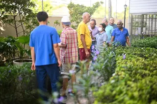 Care coordinator Thi Thi Lwin (wearing face mask) accompanying residents on a walk in the S.E.E.D Garden at St Andrew’s Nursing Home (Buangkok).