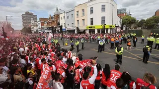 Police and Arsenal supporters waiting along parade route outside Emirates Stadium in London