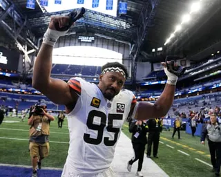 Myles Garrett lifts his hands walking off the field after a Browns game.