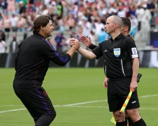Mauricio Pochettino shakes hands with assistant referee Frank Connor on a football pitch