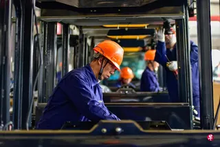 工人在中国山东省青州一家工厂的挖掘机驾驶室的生产线上工作，摄于2024年10月。 （法新社档案照）