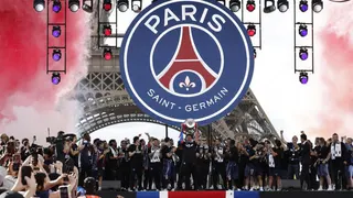 Paris St Germain's Marquinhos lifts the trophy as he celebrates with teammates after winning the UEFA Champions League.