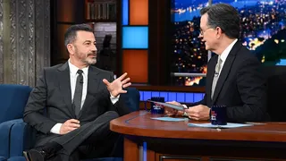 Stephen Colbert and Jimmy Kimmel seated on The Late Show set