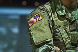 Cropped shot of a soldier wearing camouflage fatigues with an American flag for a patch.