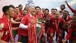 Arne Slot lifts the Premier League trophy surrounded by his players