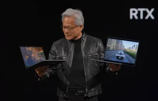 Nvidia’s CEO holds up two RTX Spark laptops at Computex.