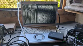 old japanese laptop running nar clepto. A SSD is attached to it. The computer is plugged to a ethernet switch.