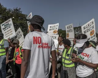 A person wearing a T-shirt with the slogan 'No illegal immigration' takes part in a march in Durban
