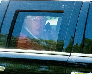 Donald Trump talking on his mobile phone in the back of his car