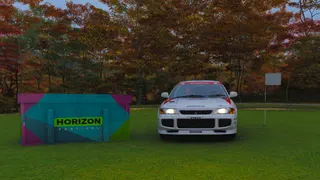 Forza Horizon 6 Minamino Treasure Hunt: A white car parked next to a treasure chest and white flag on a golf course in Autumn.