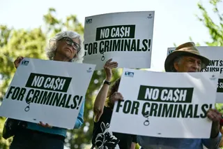 Demonstrators hold signs reading “No cash for criminals” in protest against US President Donald Trump’s IRS settlement and his “anti-weaponization fund” outside the US Capitol building in Washington on Tuesday. Photo: AFP