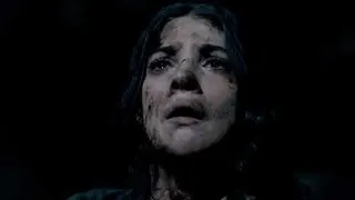 A young woman in the Until Dawn movie production gazes up, caked in dirt and filth, with a horrified expression on her face.