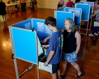 Colton Kapicka, 18, gets some help from his mother, Kelly Kapicka as he marks his ballot while voting in his first election, in Sacramento, California.