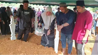 Nurul Ain Rashid pours rose water on the grave of Nur Airish Syifa Sidek during the funeral at Bandar Al-Muktafi Billah Shah Muslim Cemetery. -NSTP/Rosli Ilham