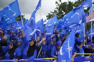Supporters of Malaysia’s Barisan National coalition led by Umno, wave flags outside the nomination centre in Langkawi Island in November 2022. Photo: AP