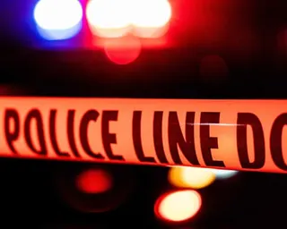 Line of police tape at night with siren colours in background