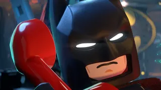Screenshot from Lego Batman Legacy of the Dark Knight showing Batman in his Batcave talking on a red phone