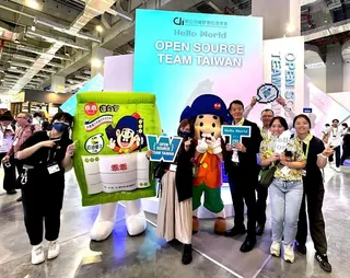 乖乖保庇巡迴現身 COMPUTEX 2026，前進數發部「Open Source Team Taiwan」展區與參展團隊互動合影，將象徵穩定運作與順利發展的守護力量帶進全球科技盛會。 (圖／乖乖提供)
