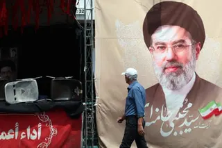 A man walks past a billboard carrying a picture of Iran’ supreme leader Mojtaba Khamenei in Tehran, Iran.
