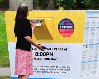 Woman slips envelope in yellow box
