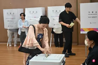 投票结束后，韩国三大电视台的联合出口民调显示，在16个广域团体长选举中，执政的共同民主党有望拿下首尔等11个地区，在野国民力量党则仅在庆尚北道保持优势，釜山、大邱、江原道和全罗北道等地仍有待开票确认。图为选民星期三在首尔的投票站投票。 （法新社）