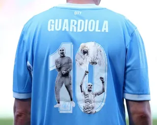 A supporter wears a Manchester City shirt paying tribute to Pep Guardiola