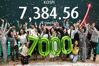 Currency dealers celebrate in front of a screen showing South Korea’s benchmark stock index during a ceremony celebrating it breaking 7,000 points at the Hana Bank headquarters in Seoul on May 6. Photo: AFP