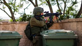 Israeli soldier scanning area while taking cover near Israel-Lebanon border