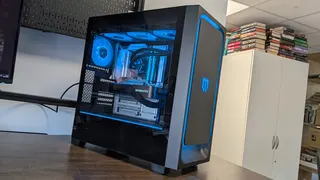 A photo of a Maingear MG-1 Mk.II gaming PC on a desk, with its RGB lighting enabled