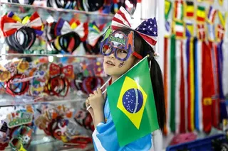 A girl displays football fans' headwear at the Yiwu International Trade Market on 19th April,2026 in Yiwu, Zhejiang province, China