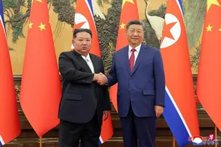 中国国家主席习近平（右）去年9月4日在北京与朝鲜领导人金正恩会面时握手致意。 （朝中社／法新社）