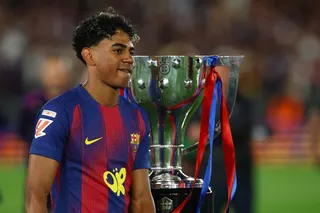 Barcelona's Lamine Yamal celebrates next to the trophy after winning the La Liga