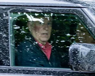 Andrew Mountbatten-Windsor seen through the side window of his Range Rover with a wide dark red blemish across his upper cheek