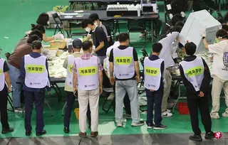6月5日，首尔地方选举一个计票站的选举官员整理选票。 （法新社）