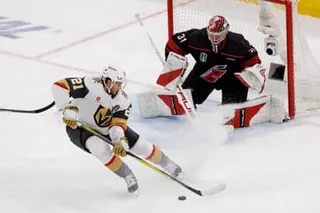 The Golden Knights' Brett Howden (21) handles the puck in front of Hurricanes goaltender Frederik Andersen (31) during the second period.